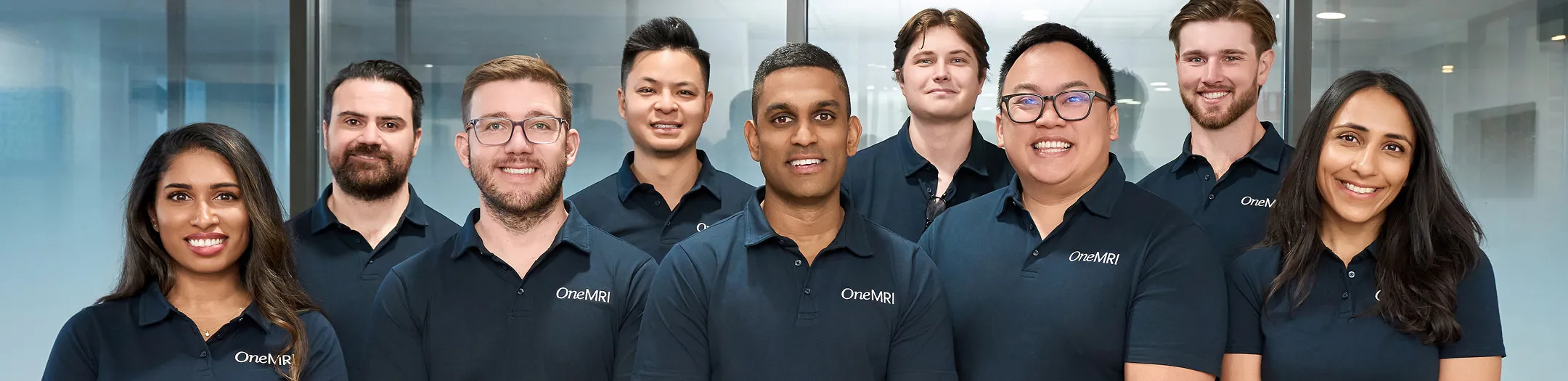 Group photo of OneMRI staff smiling in clinical uniforms